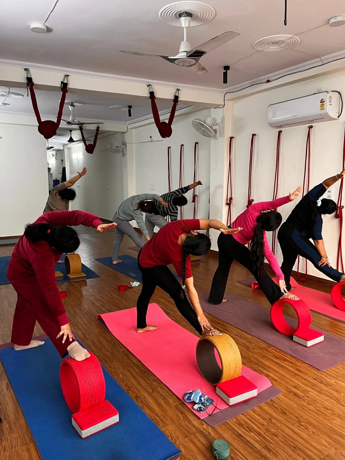 Students using yoga wheels and blocks during a side-bend sequence at Veda Yoga Studio